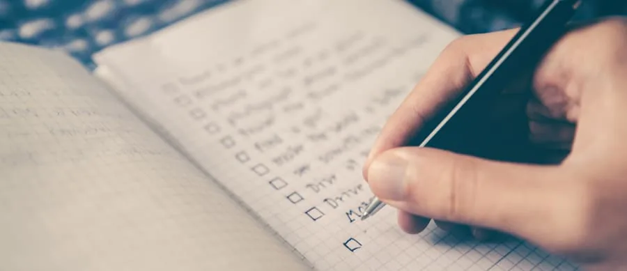 person writing goals on notepad