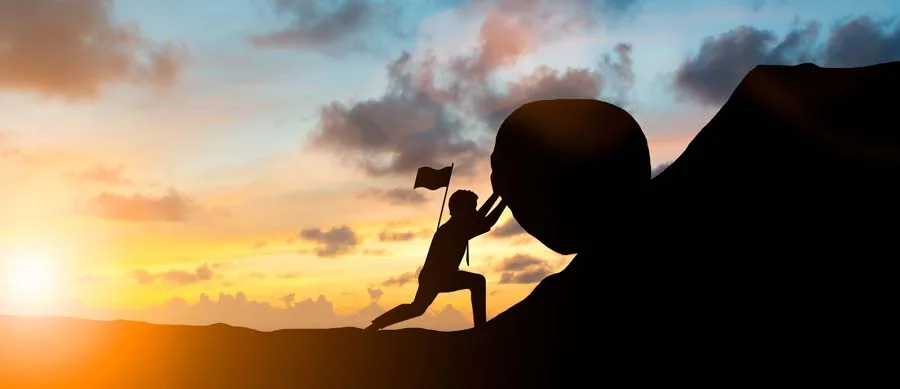man pushing a boulder