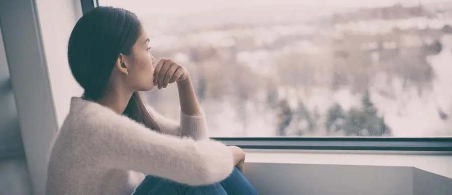depressed woman looks outside