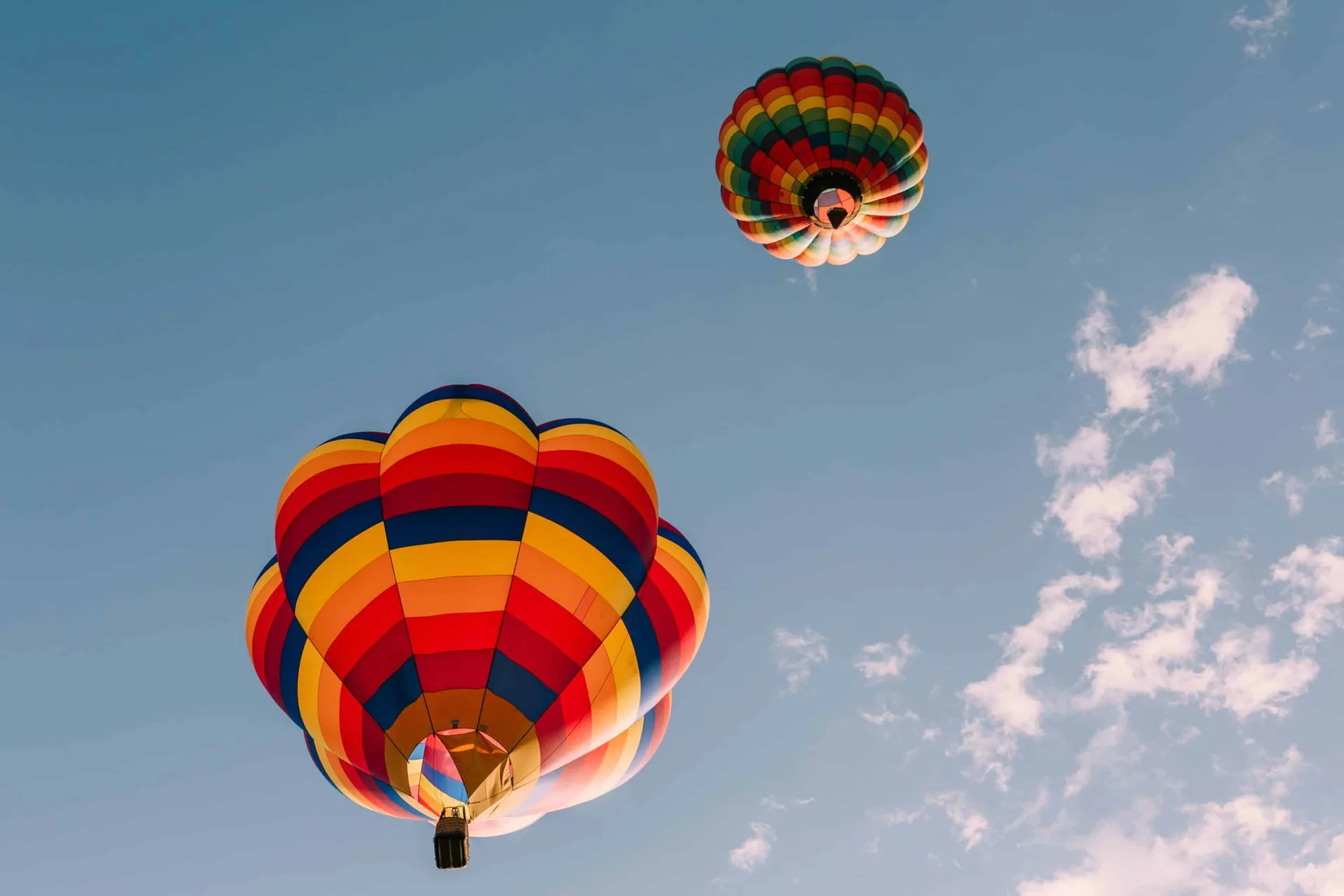 Two colorful hot air balloons soaring above Colorado Springs, symbolizing freedom and recovery in sober living Colorado Springs.