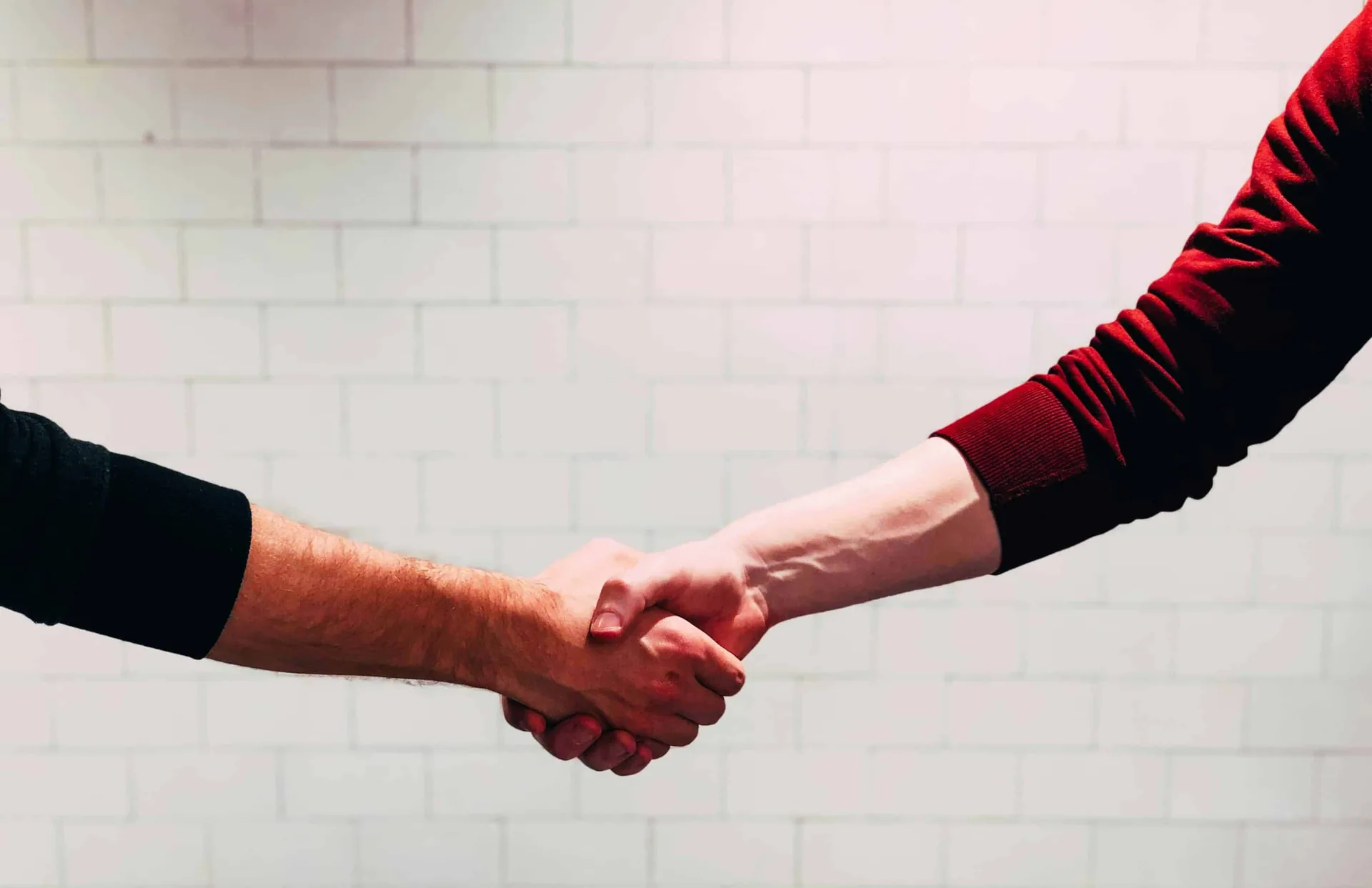 Two people shaking hands symbolizing accountability and trust in recovery support.