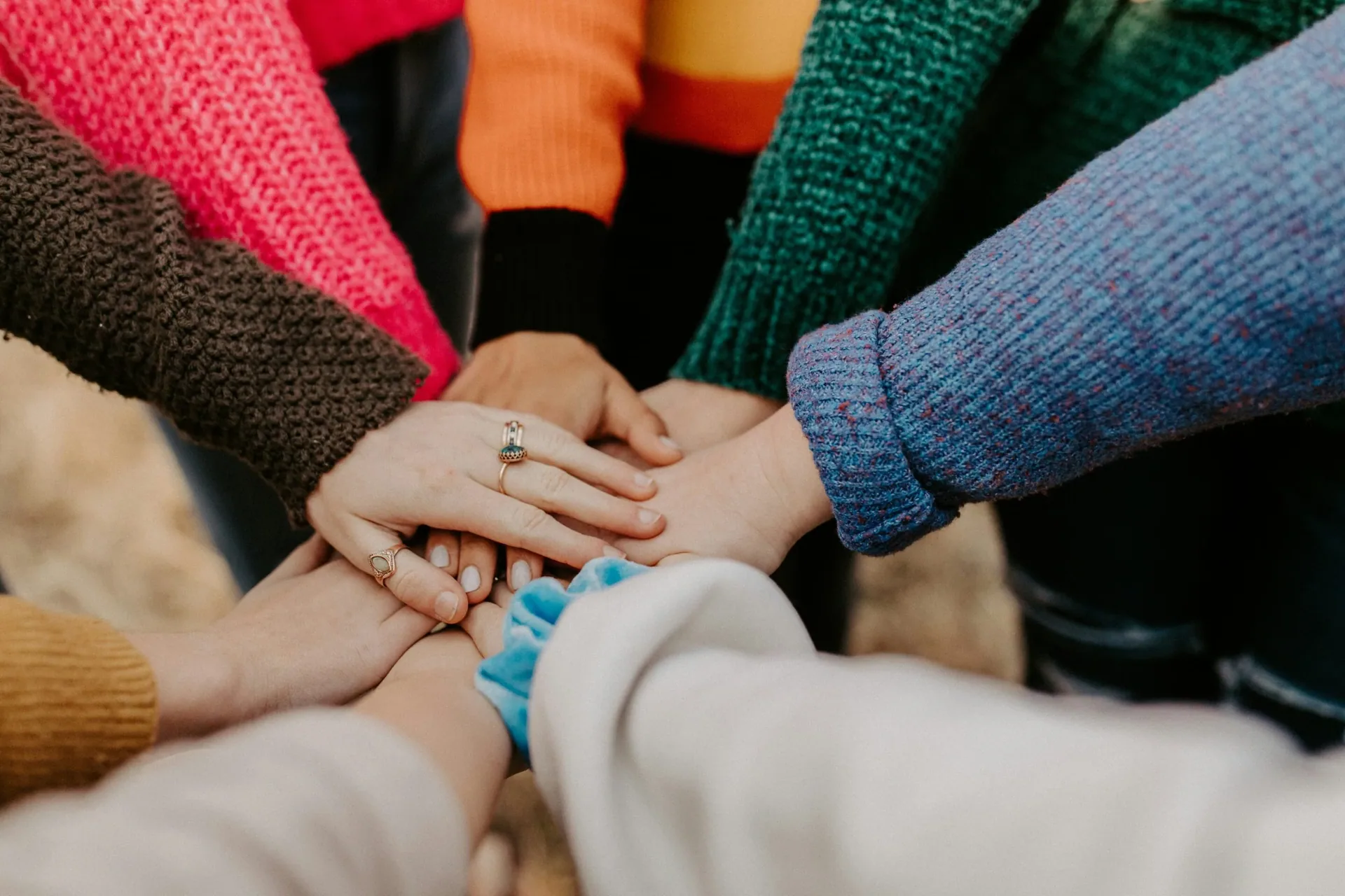 Stacked hands symbolizing accountability and teamwork in recovery support.