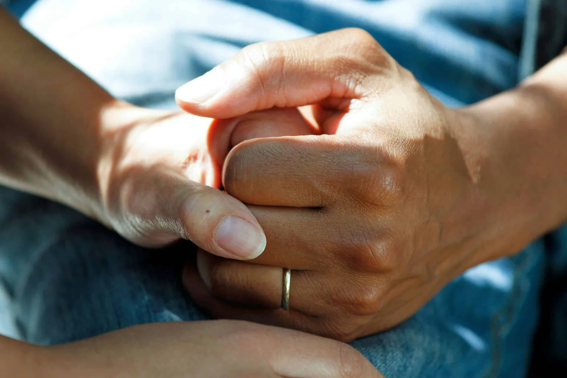 Close-up of hands holding together, symbolizing trust and encouragement in recovery support.