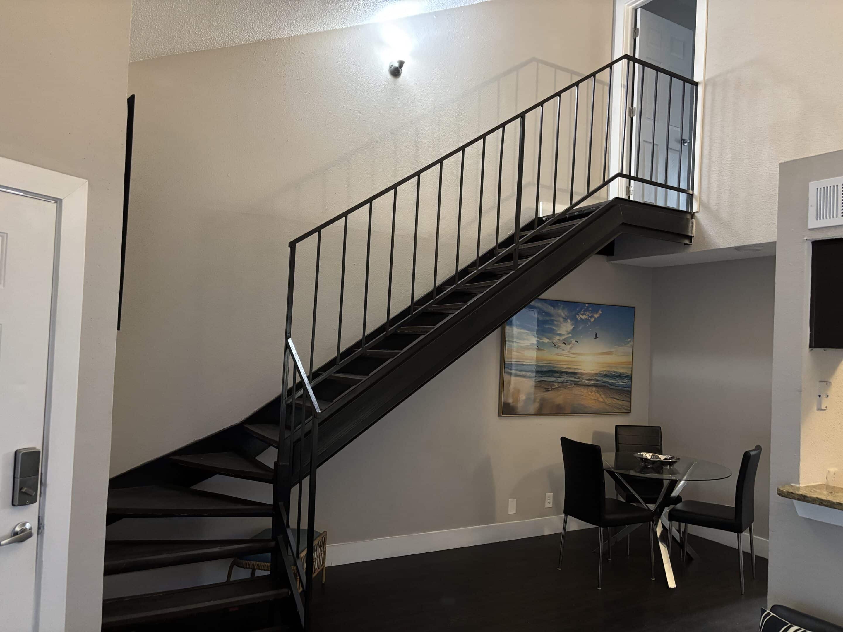 Two-bedroom men’s sober living apartment in Austin with modern staircase and dining area