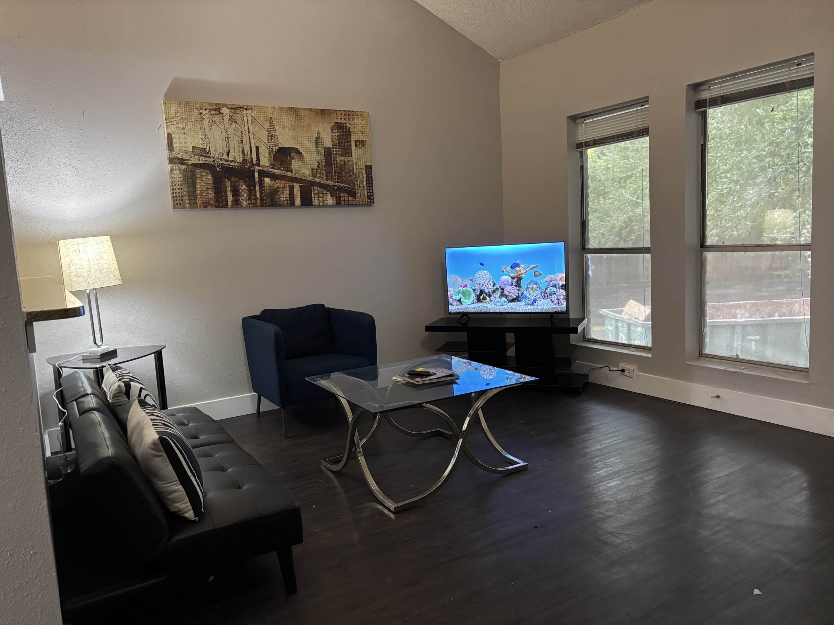 Modern living room inside two-bedroom men’s sober apartment in Austin with natural light and comfortable seating