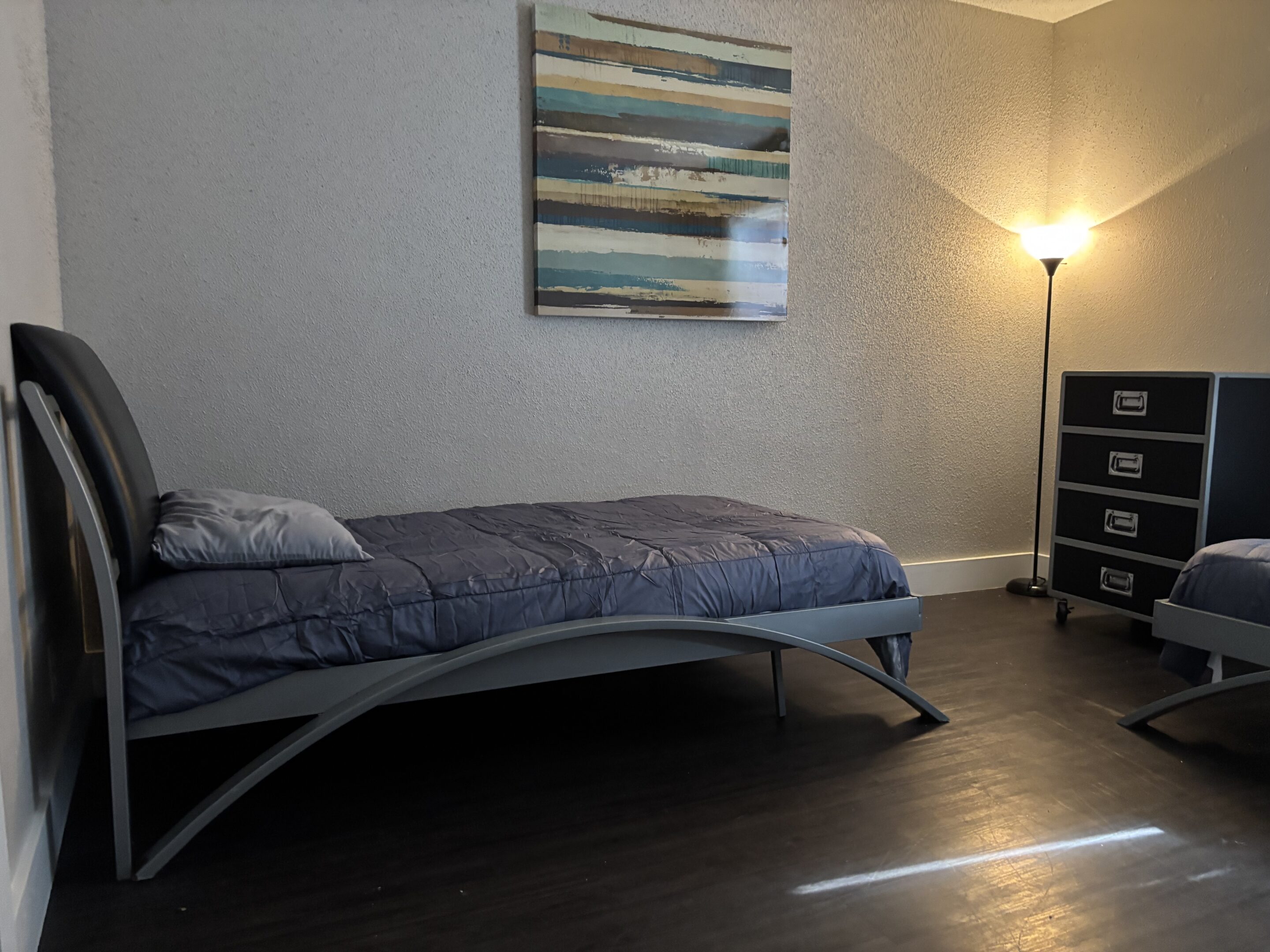 Shared two-bedroom men’s sober living space in Austin with twin beds and modern décor