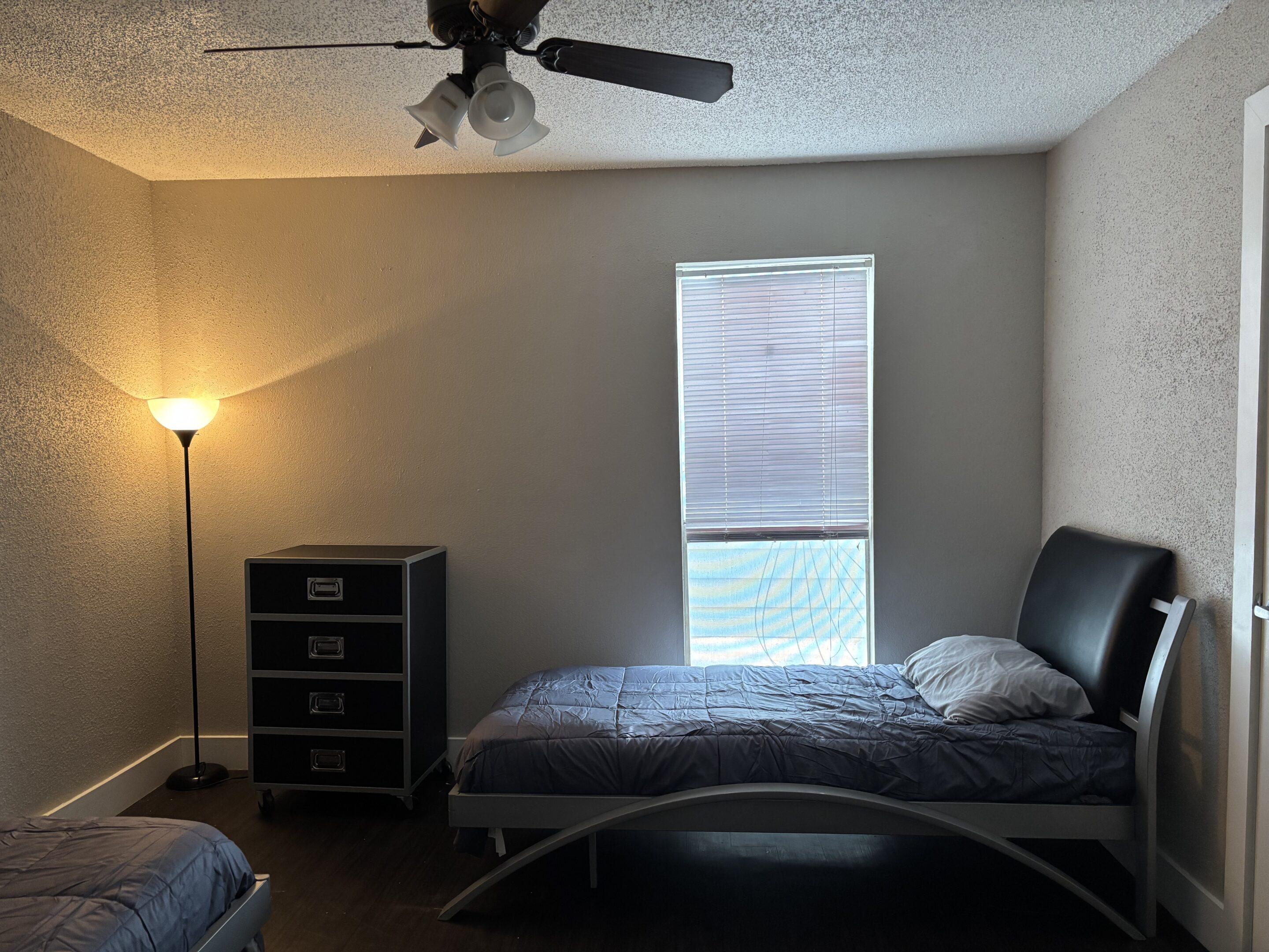 Affordable two-bedroom men’s sober living in Austin with twin beds, dresser, and soft lighting