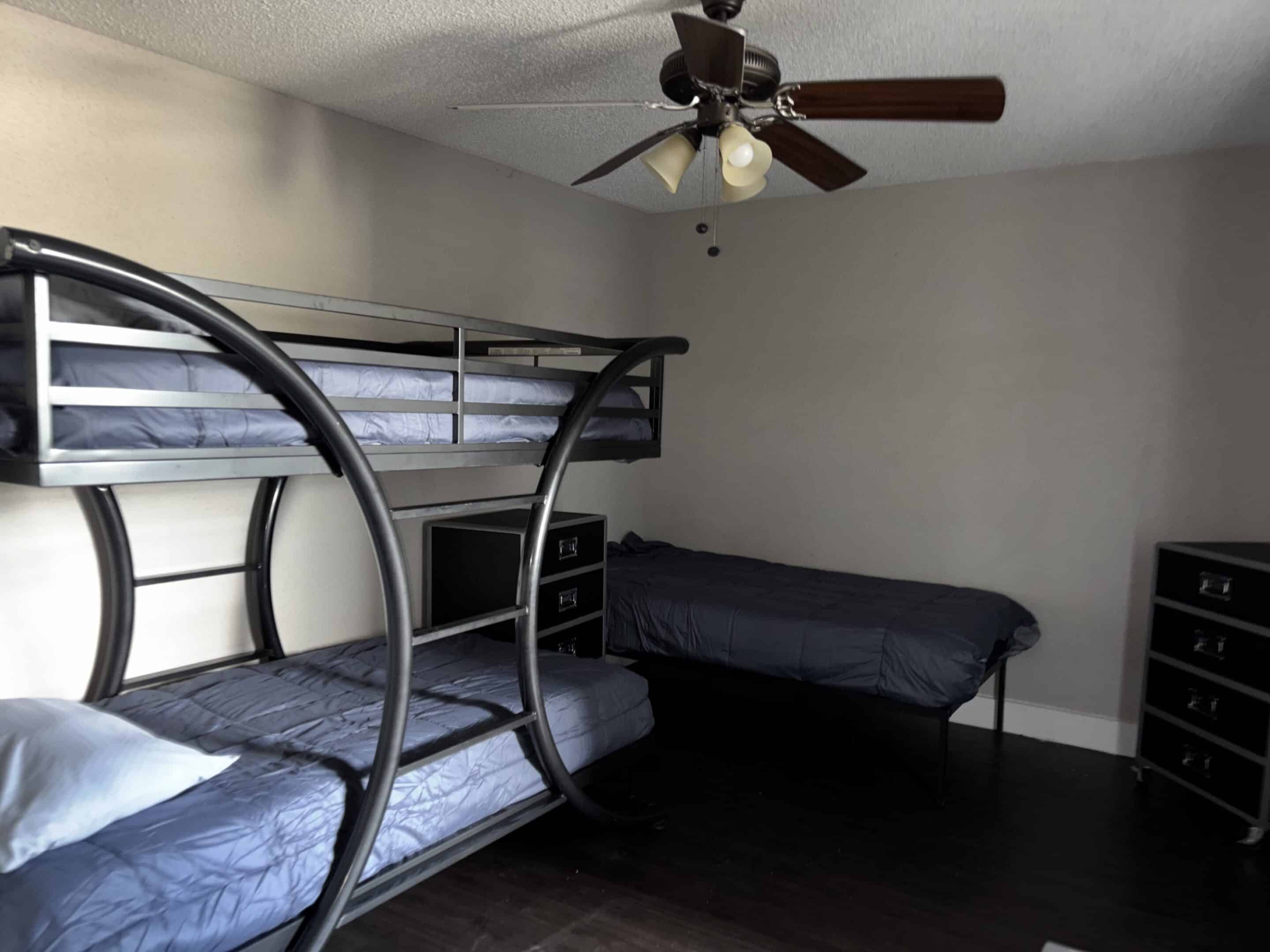 Shared living area in men’s sober housing Austin with brown sofa and glass tables