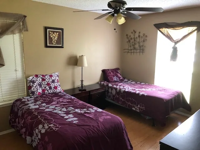Shared bedroom with twin beds and natural light at Eudaimonia’s Parkfield Drive women’s sober living home in Austin.