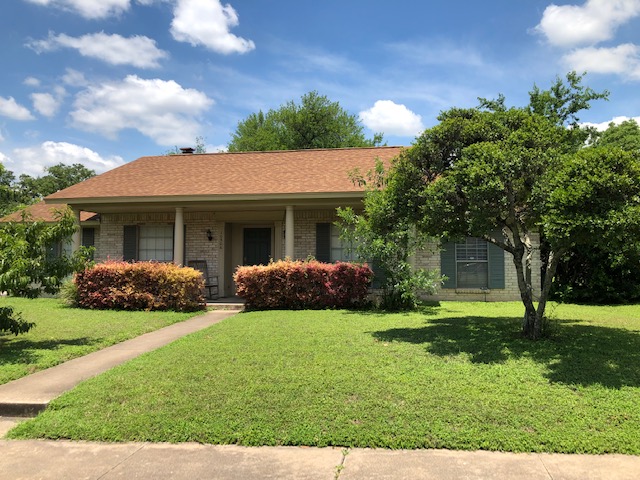 Front view of Eudaimonia’s Parkfield Drive women’s sober living home in Austin, Texas with green lawn and brick exterior.