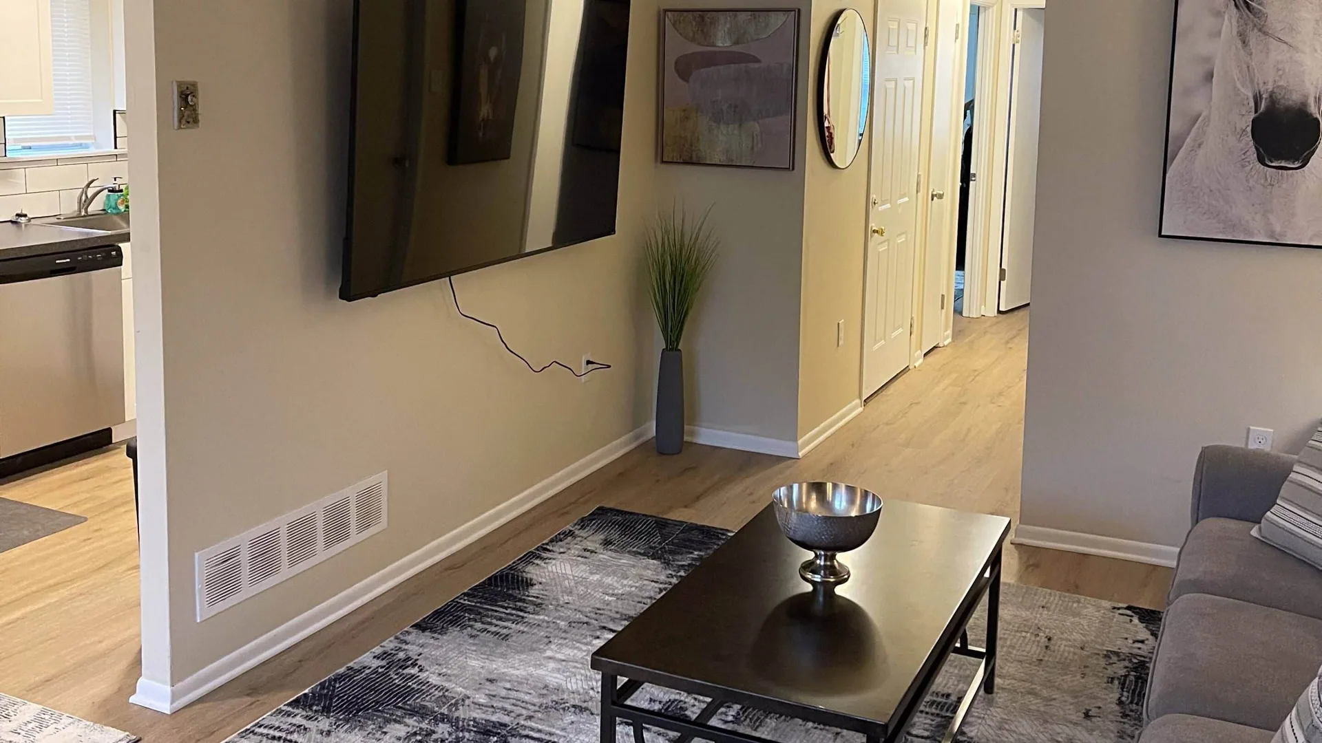 Living room with a wall-mounted mirror, low coffee table and a patterned rug.