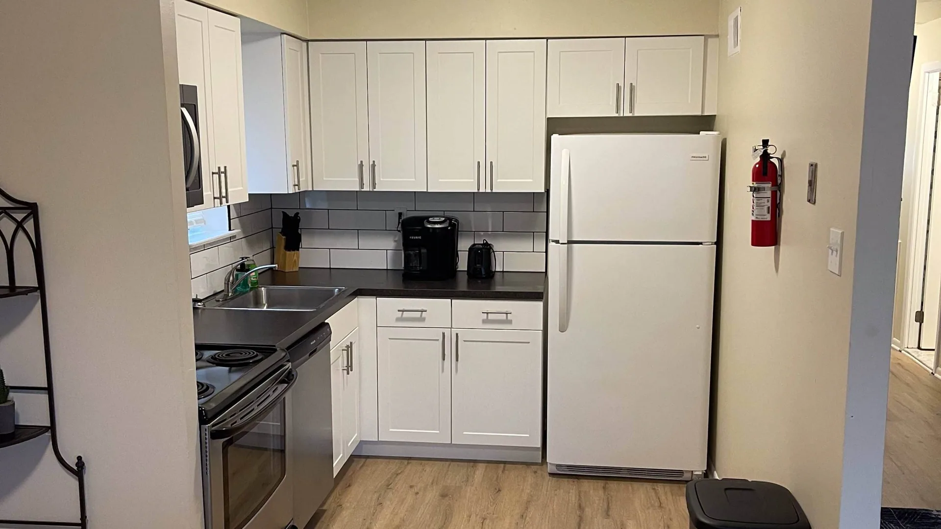 Kitchen with white cabinets, a white refrigerator and a stainless range.
