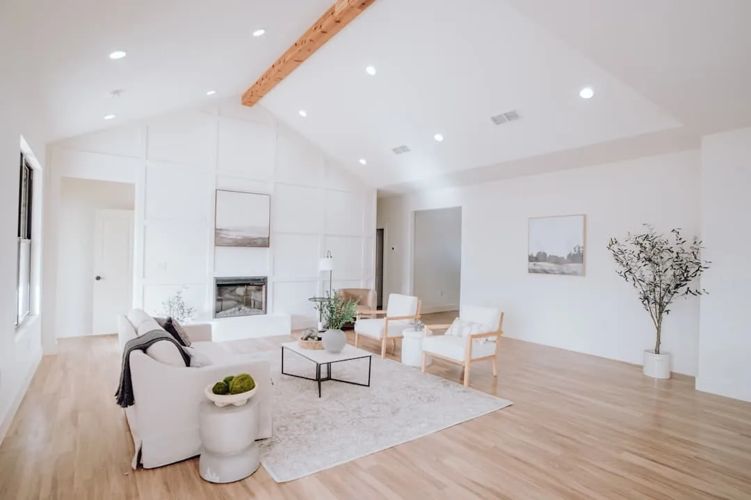 a living room with white furniture and wood floors -- Photo by Bailey Alexander on Unsplash