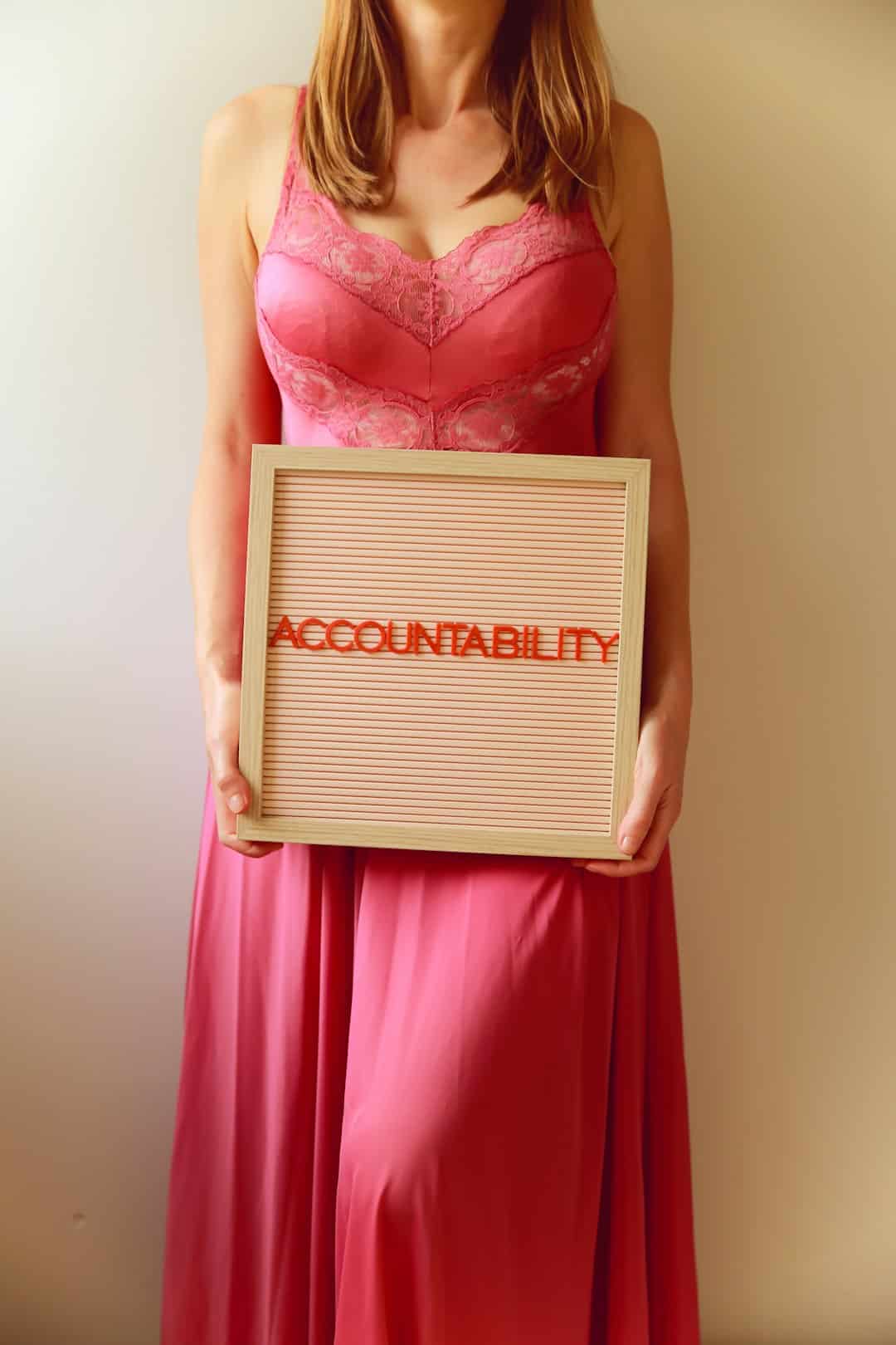 Woman holds a sign reading "accountability." -- Photo by Ava Sol on Unsplash