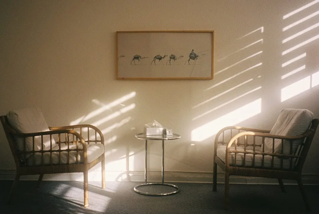 Two chairs and a table with sunlight streaming in. -- Photo by Maximilian Bungart on Unsplash