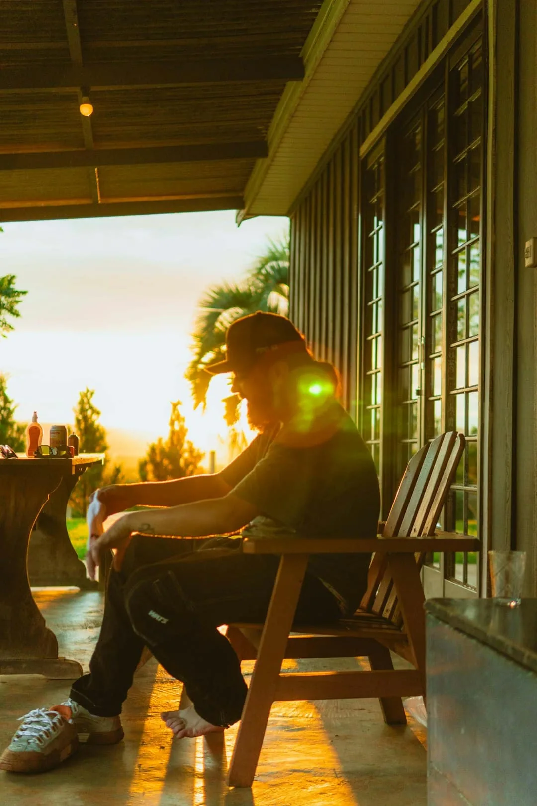Man sitting on porch during sunset -- Photo by Studio Lego on Unsplash