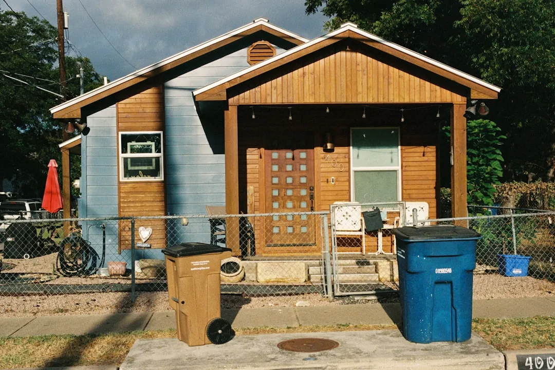 Small wooden house with a porch and trash cans. -- Photo by Sasha Matveeva on Unsplash
