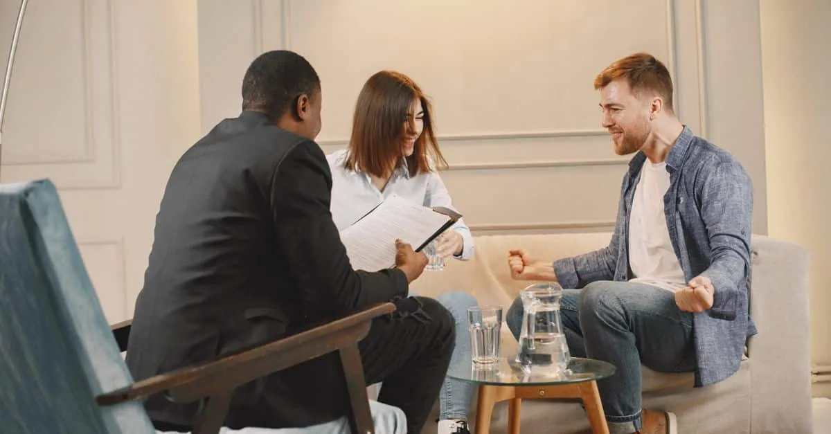 Three professionals engaged in a collaborative meeting in a modern office setting.