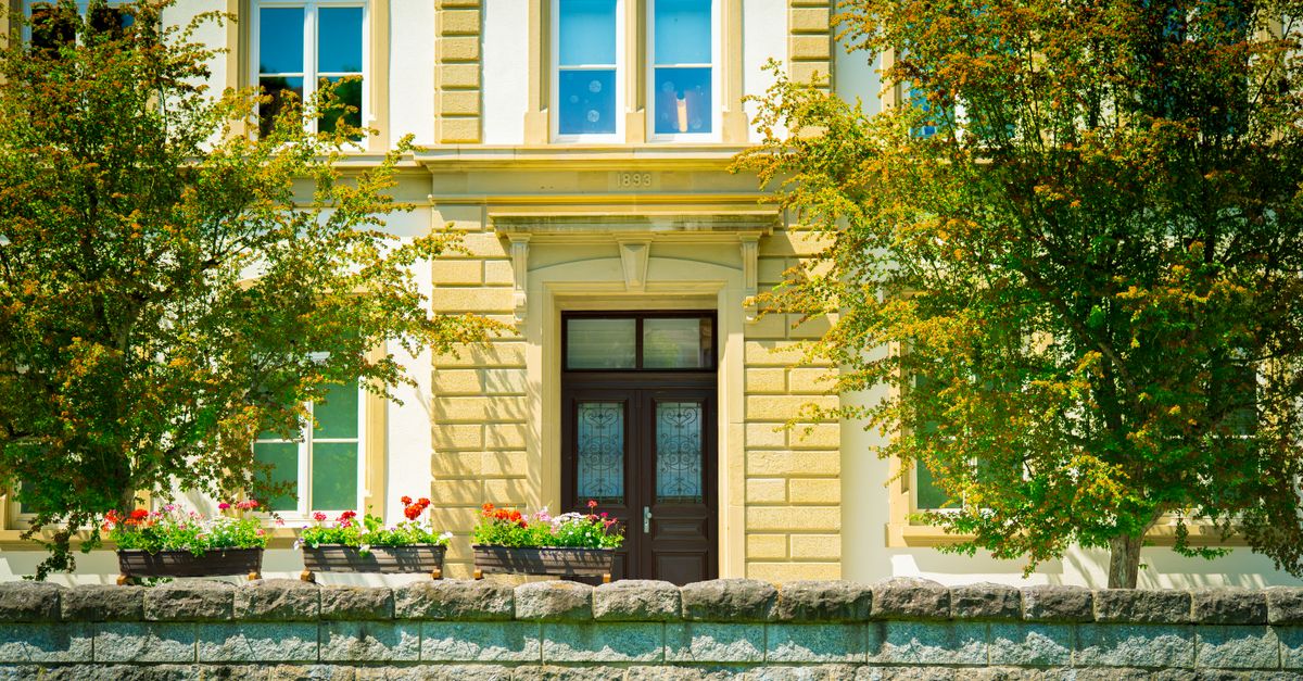 Sophisticated architecture with flowers and trees enhancing a stately European facade.