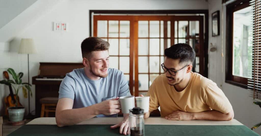 Two friends sharing a moment over coffee in a cozy indoor setting, expressing joy and friendship.