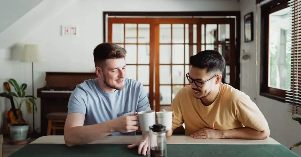 Two friends sharing a moment over coffee in a cozy indoor setting, expressing joy and friendship.