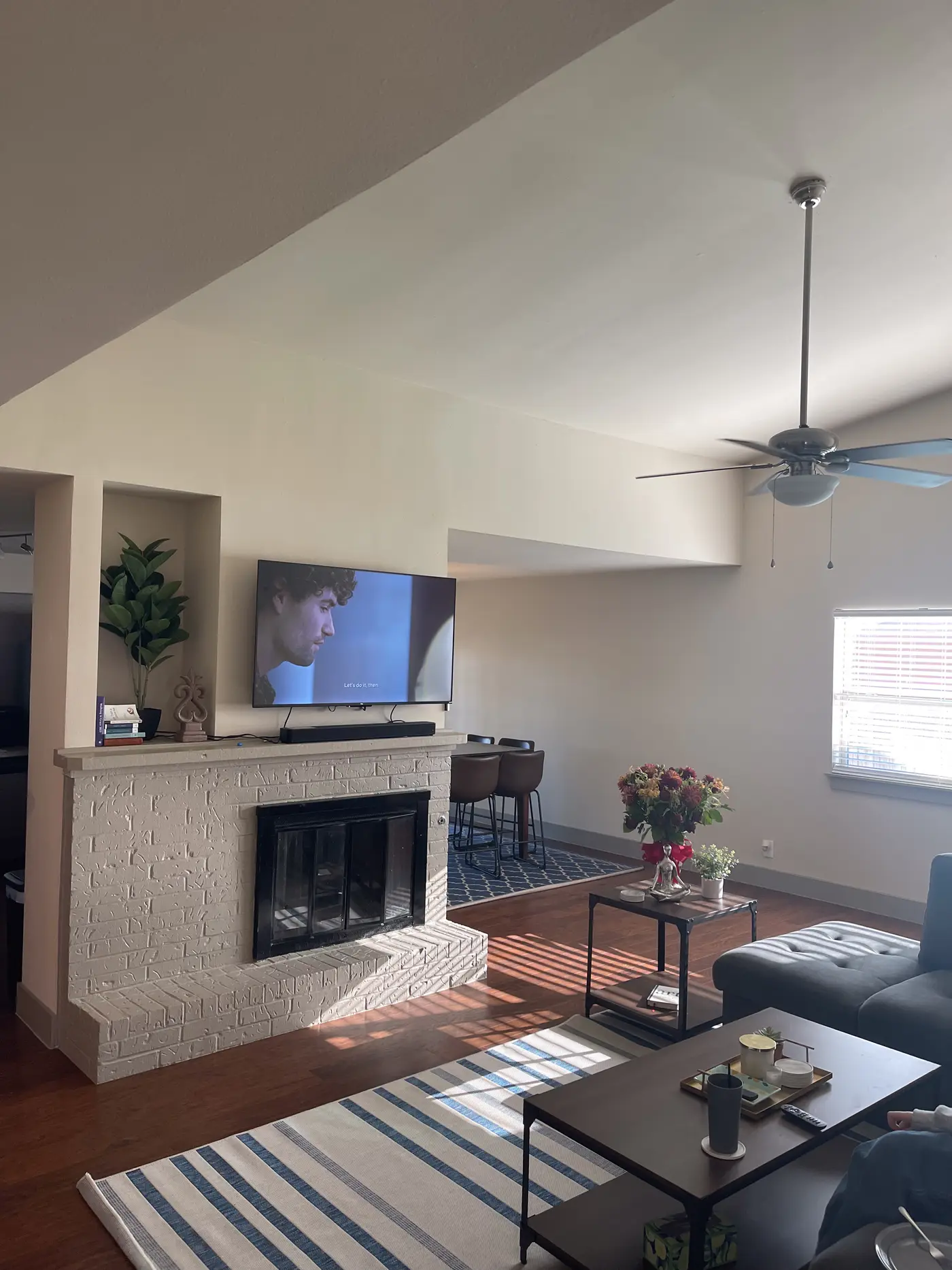 Living room with a fireplace, television and a glass coffee table.