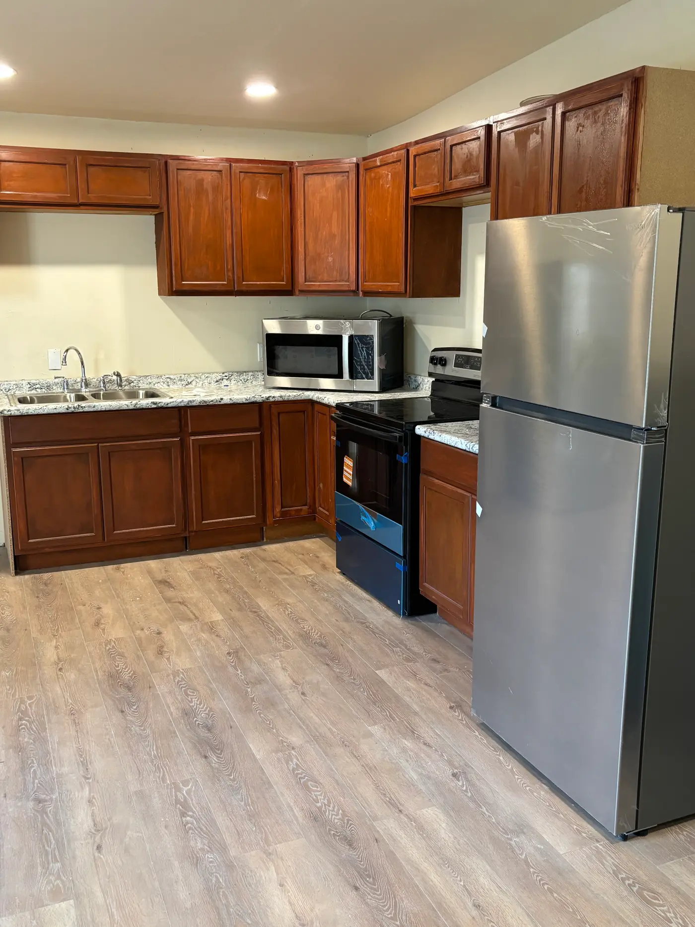 Kitchen with cherry cabinets, a stainless range and refrigerator.