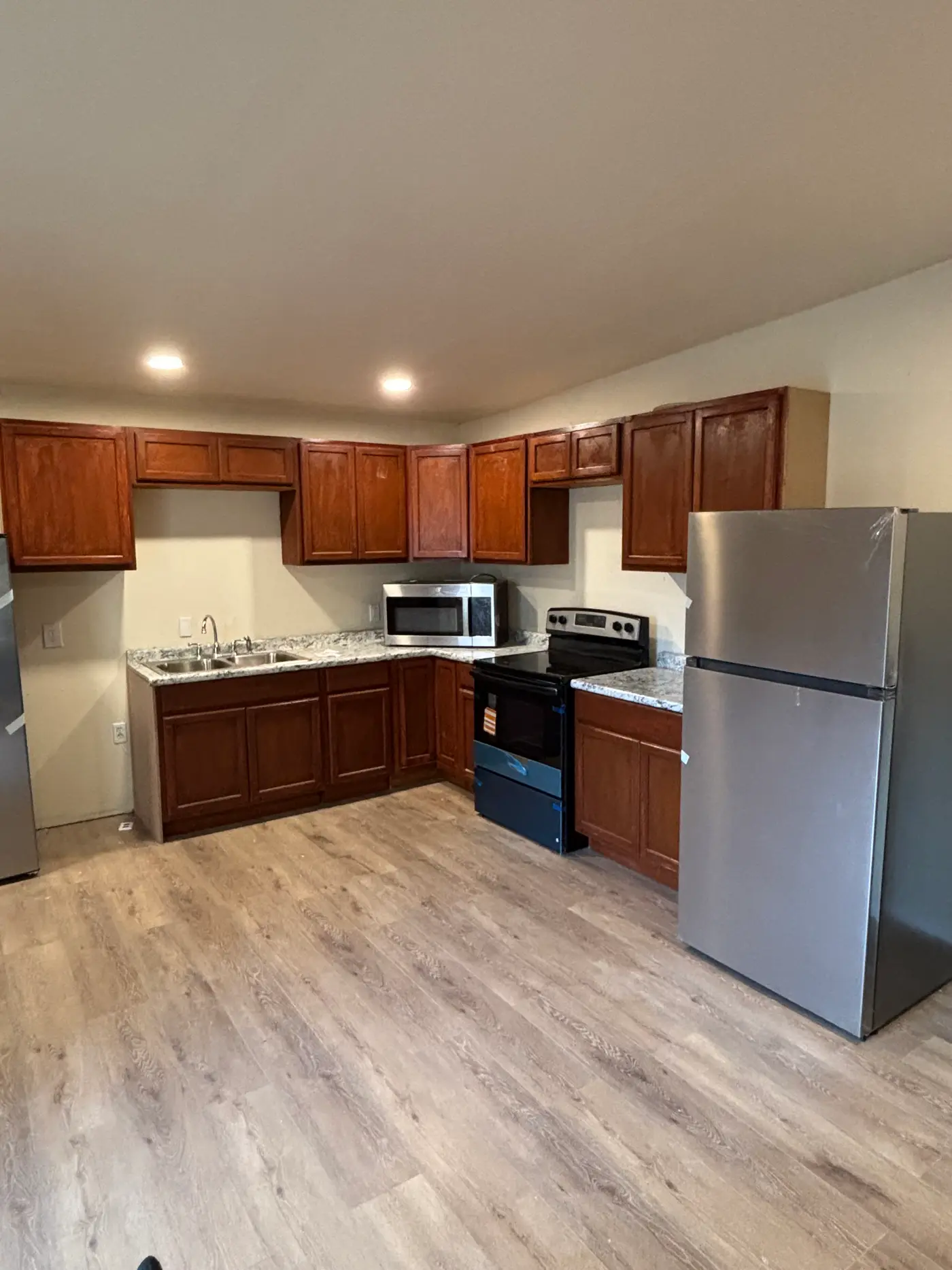 Kitchen with fitted cabinets and a stainless refrigerator.