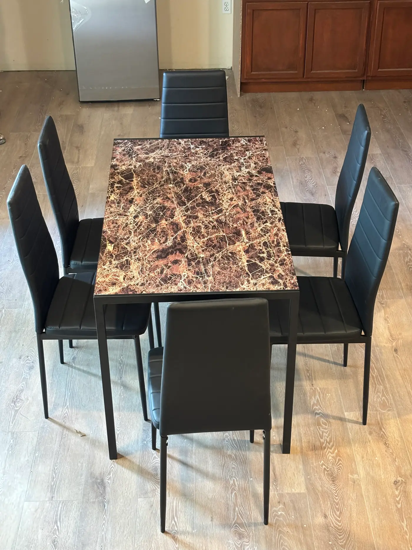Dining table and chairs with the kitchen beyond.