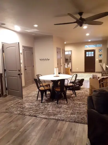 Dining table and chairs in an open-plan room with a large rug.
