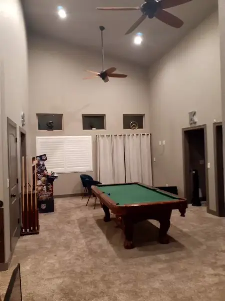 Games room with a pool table and a vaulted ceiling.