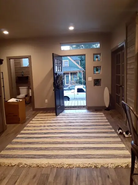 Entrance hall with a runner and the front door open to the street.