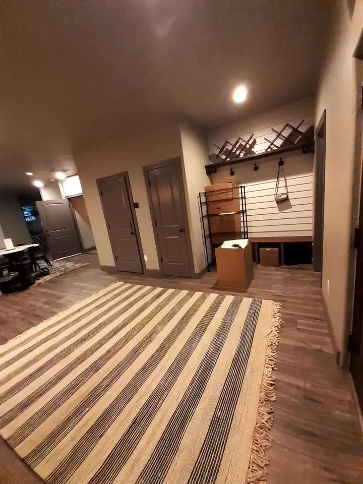Hallway with a striped runner on wood flooring.