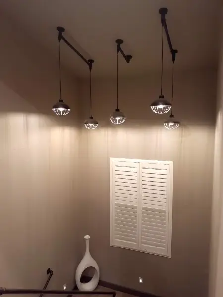 Hallway beneath three pendant lights.
