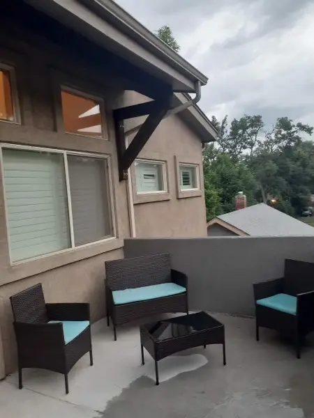 Patio with wicker chairs and a table outside the house.