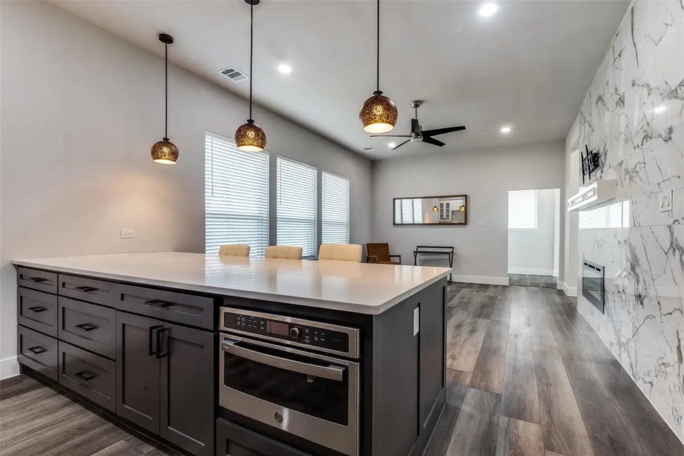 Kitchen island with a built-in oven and pendant lights.