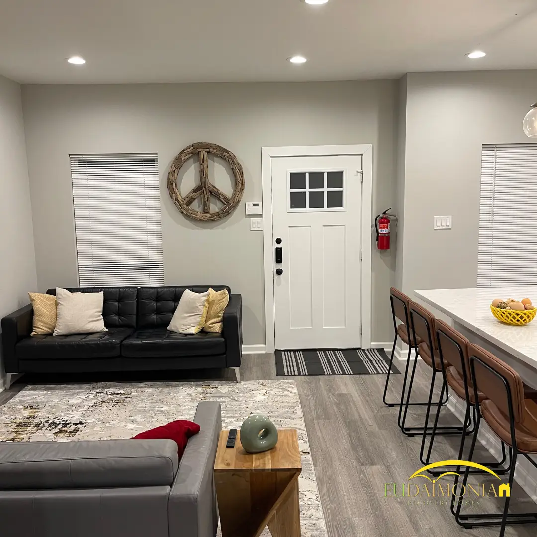 Living room with a gray sofa and a breakfast bar beyond the seating.