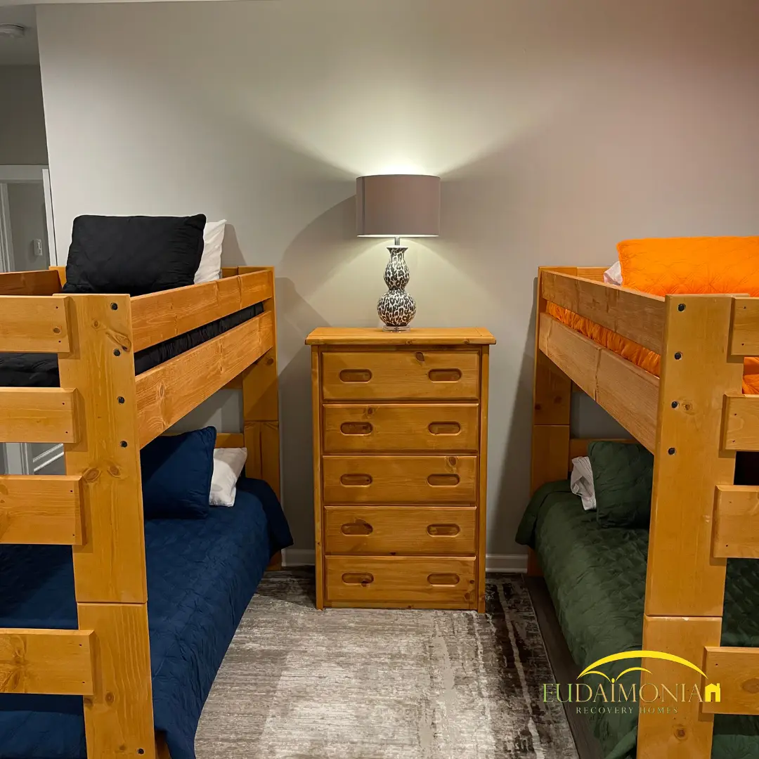 Two pine bunk beds either side of a wooden dresser.
