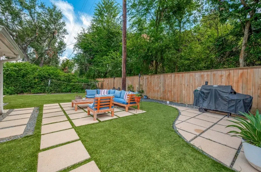 Back yard with a paved patio, outdoor sofa and lawn.