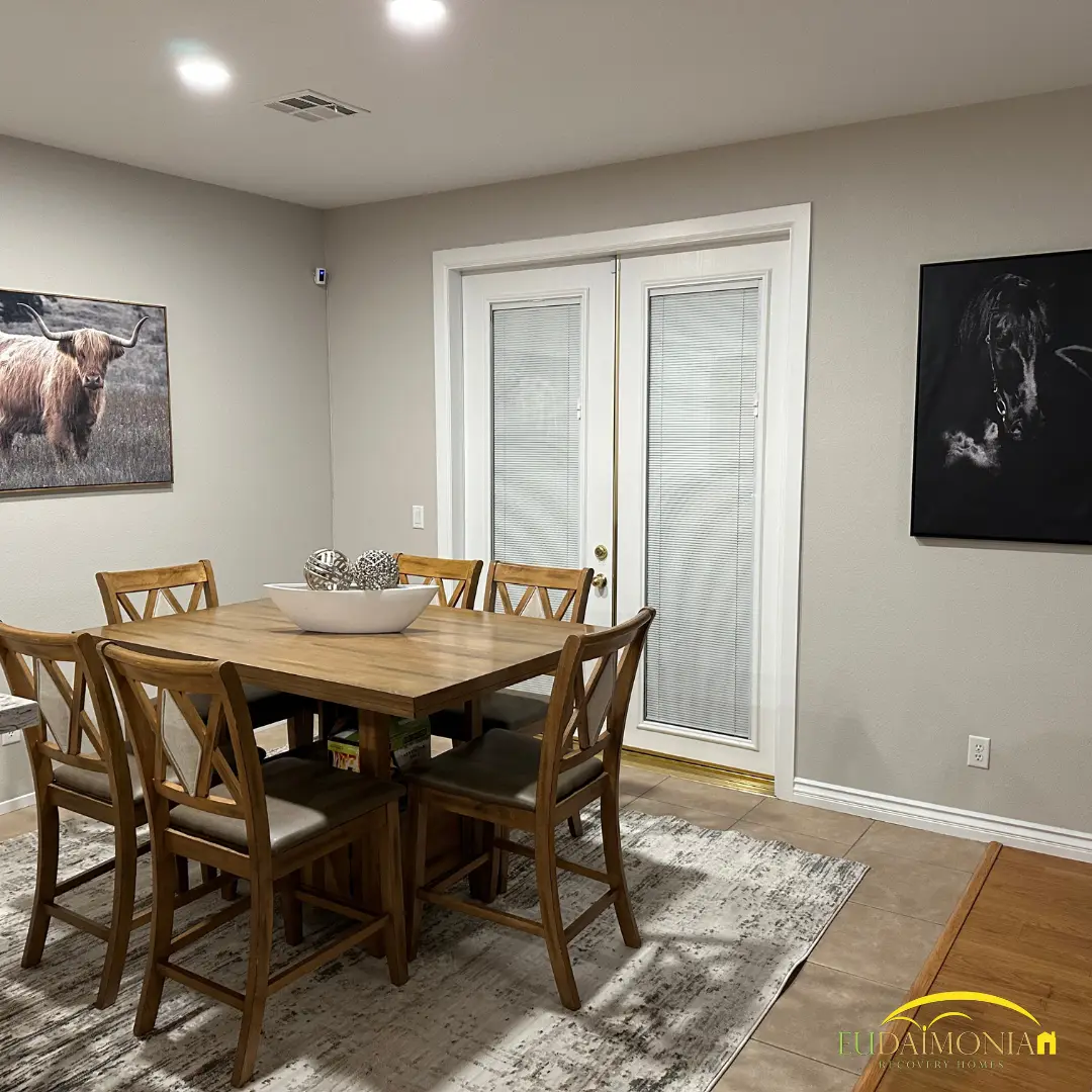 Dining table and chairs beside French doors to the garden.
