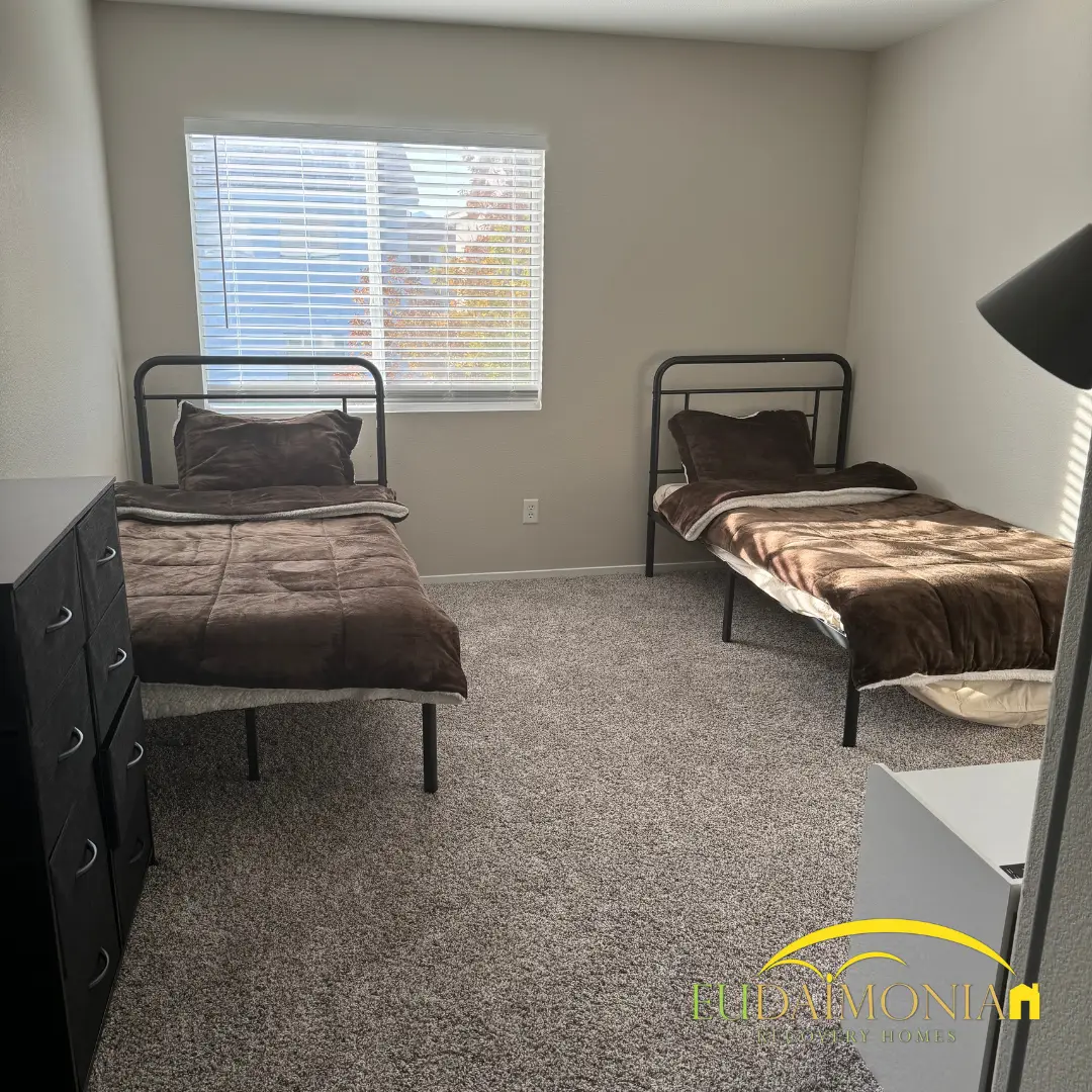Bedroom with two single beds either side of a dark chest of drawers.
