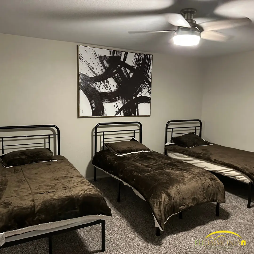 Bedroom with two single beds and framed artwork.