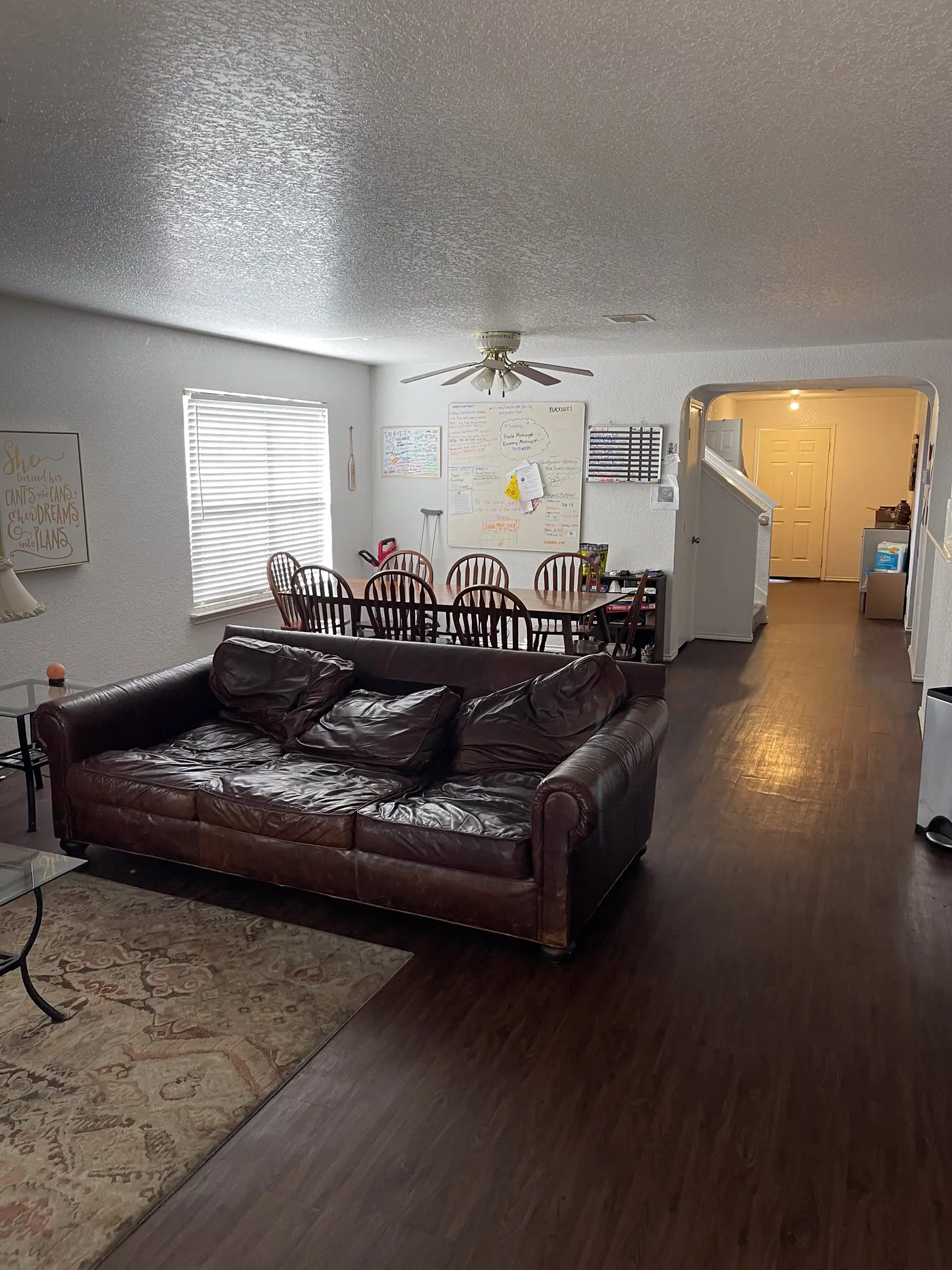 Living room with a leather sofa and the staircase beyond.