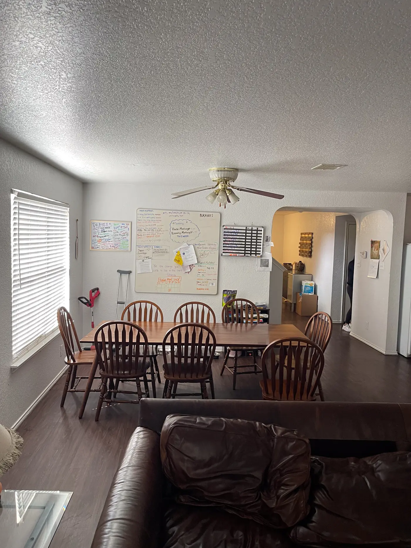 Dining area with a wooden table and chairs beside a shuttered window.