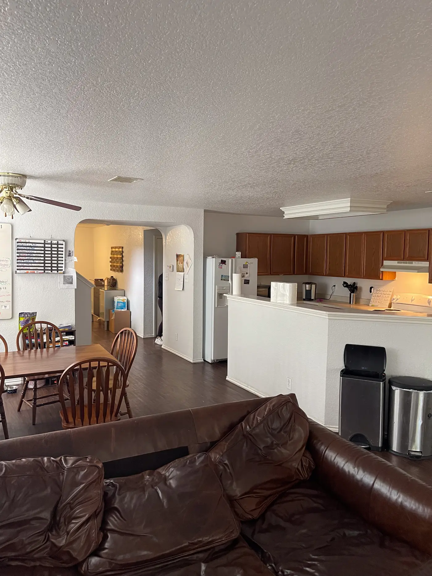 Dining table with the kitchen and breakfast bar beyond.