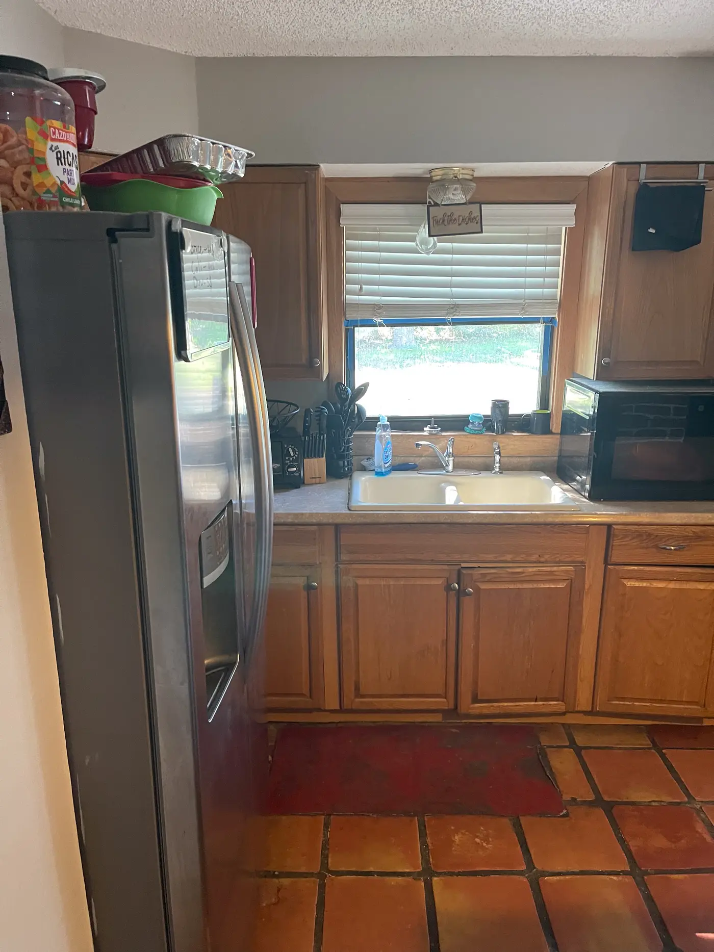 Kitchen with a stainless refrigerator and a window above the sink.