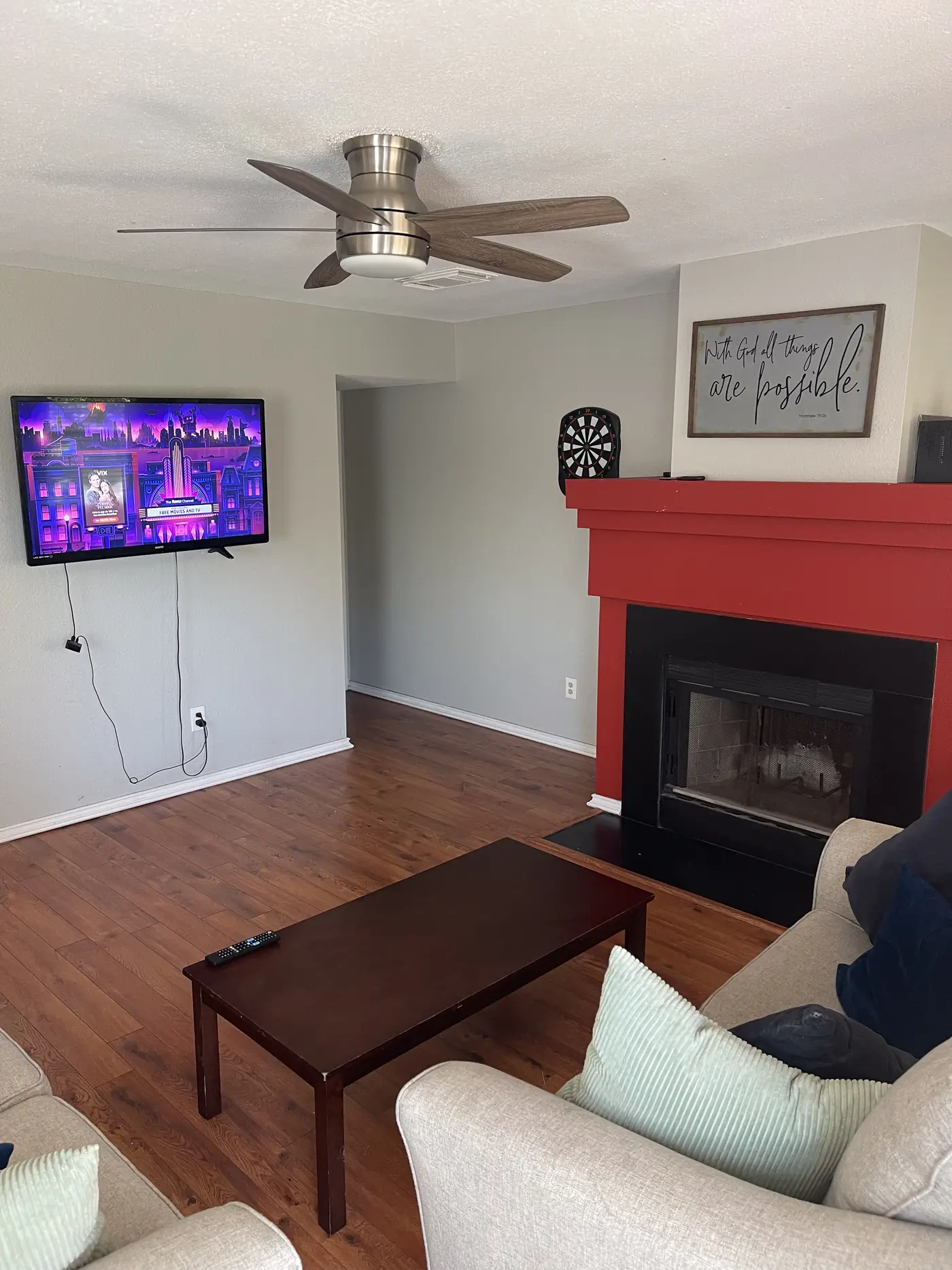 Living room with a television on the wall beside the fireplace.