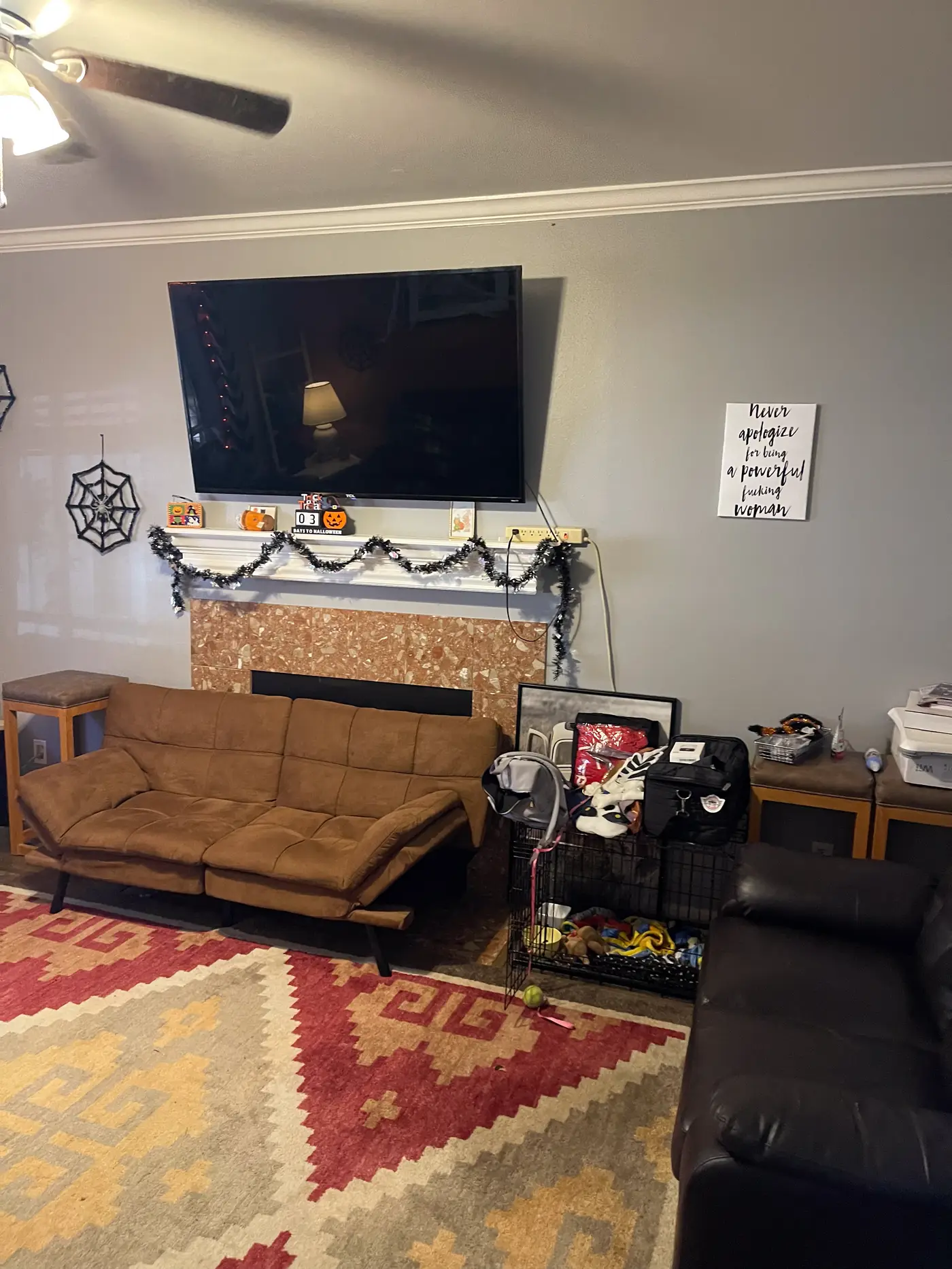 Living room with a fireplace, wall-mounted television and a leather sectional.