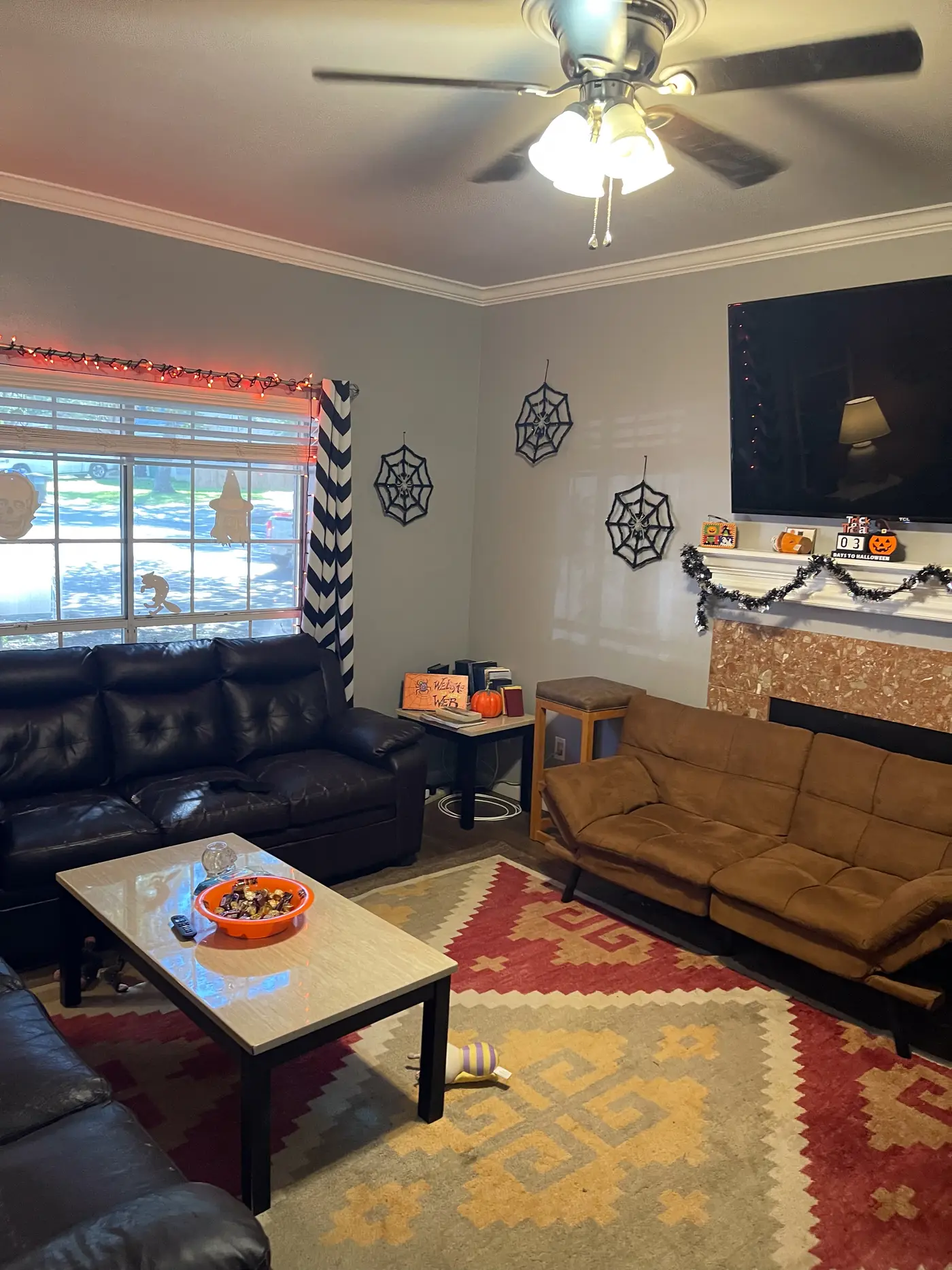 Living room with two leather sofas either side of a patterned area rug.