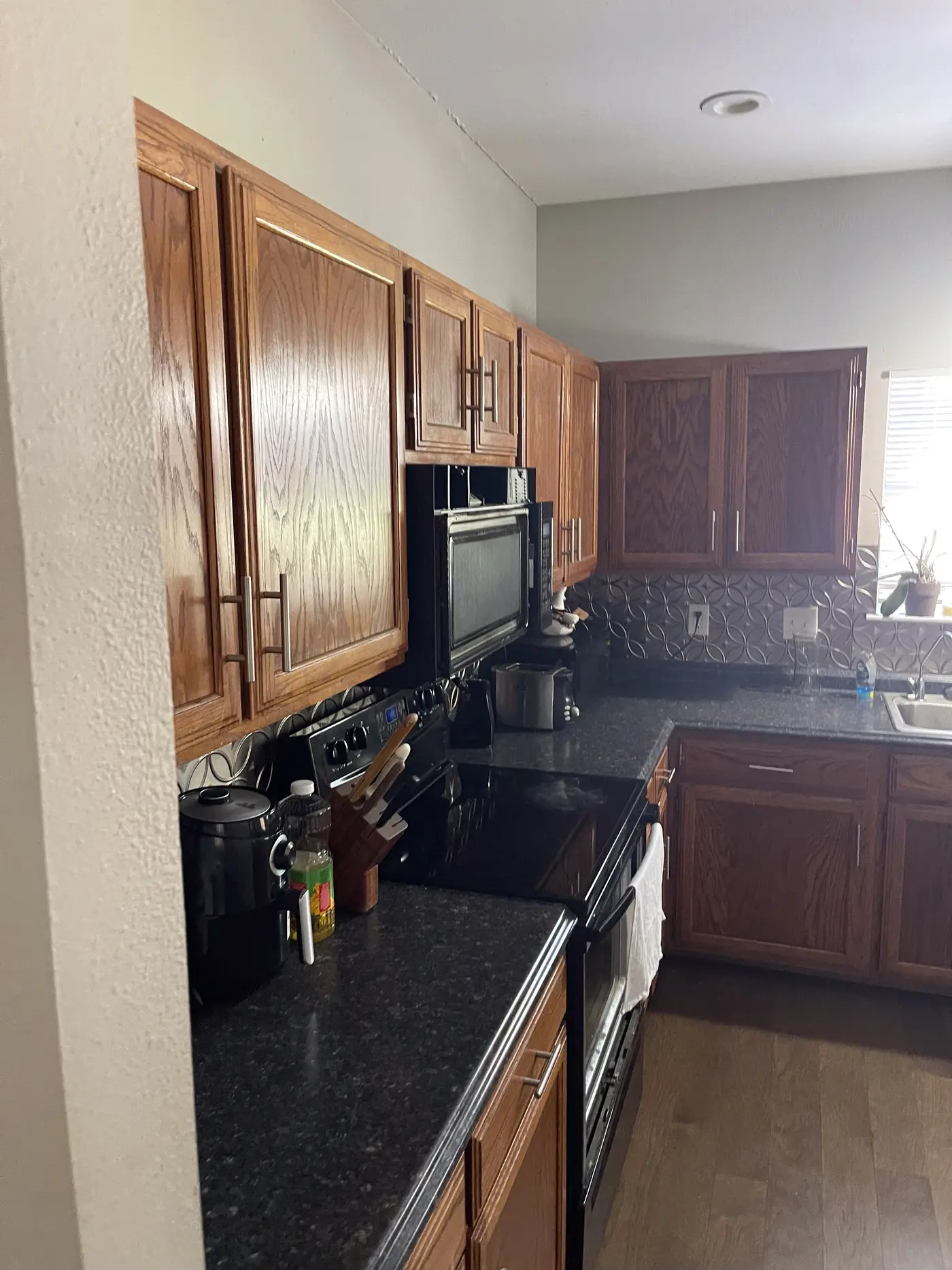 Kitchen with wood cabinets, dark counters and a stainless range.